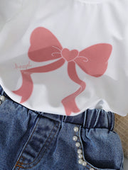 White tee with pink bow print and pearl-trimmed denim shorts.
