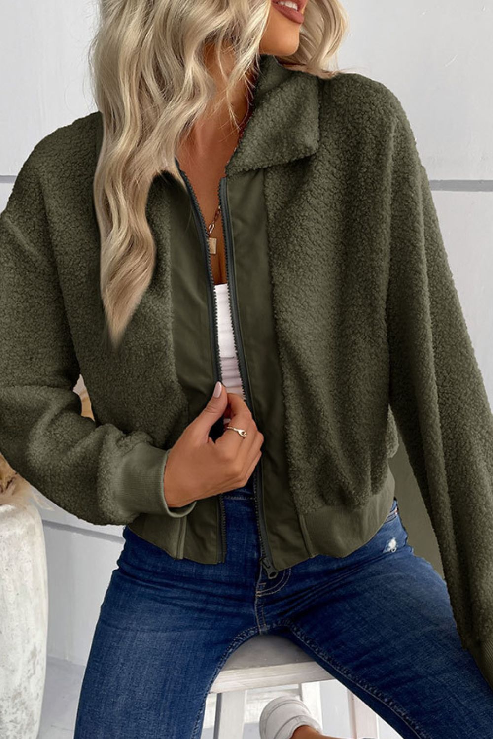Green teddy fleece bomber jacket with collared neck and zip front, styled with jeans.