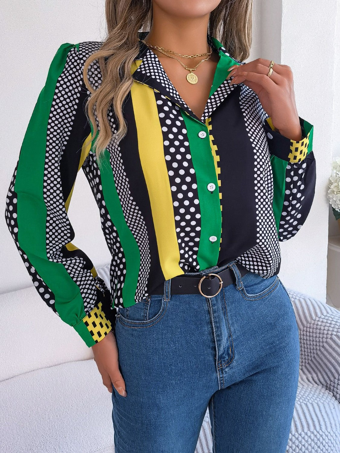 Collared blouse with bold vertical stripes and polka dots in black, white, yellow, and green.
