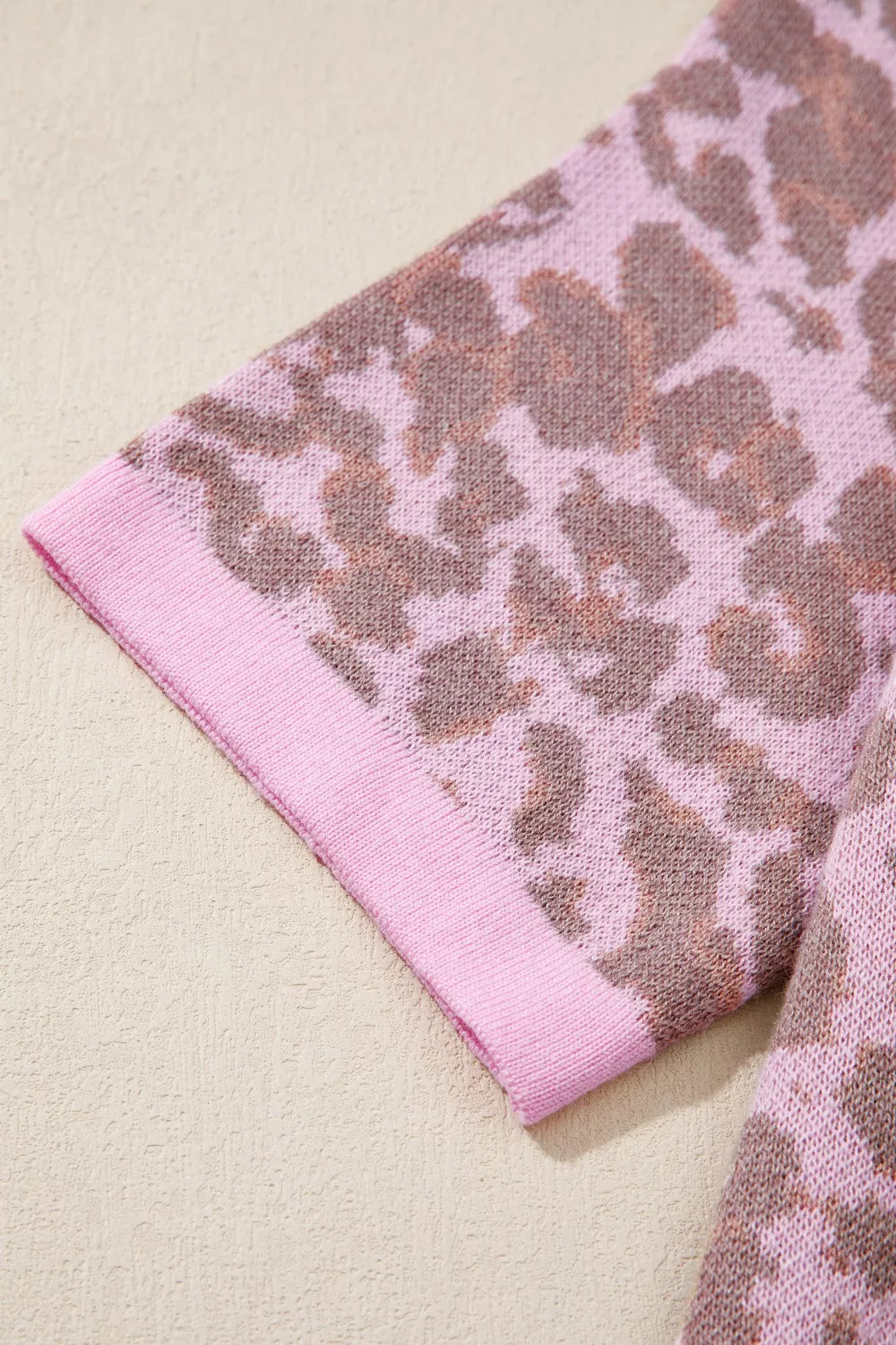 Cardigan with pink and brown leopard print knit fabric and pink trim on the sleeve.