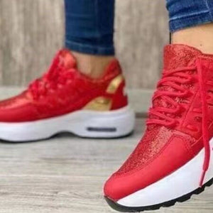 Red lace-up chunky platform sneakers with glitter accents and gold detailing.