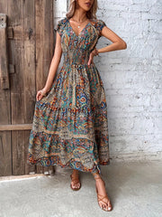 Vibrant tiered maxi dress with smocked bodice, V-neck, short sleeves, and paisley print.