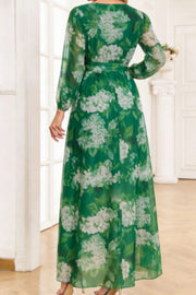 Green floral print maxi dress with tied waist and long sleeves.
