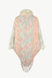 Textured knit cape with faux fur collar and fringe hem in pastel multicolor yarn.
