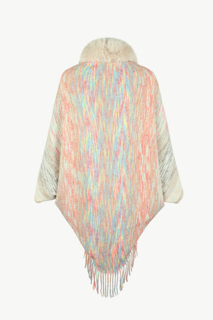 Textured knit cape with faux fur collar and fringe hem in pastel multicolor yarn.