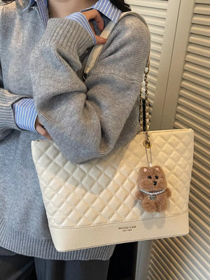 Luxurious quilted ivory shoulder bag with chain strap and bear charm
