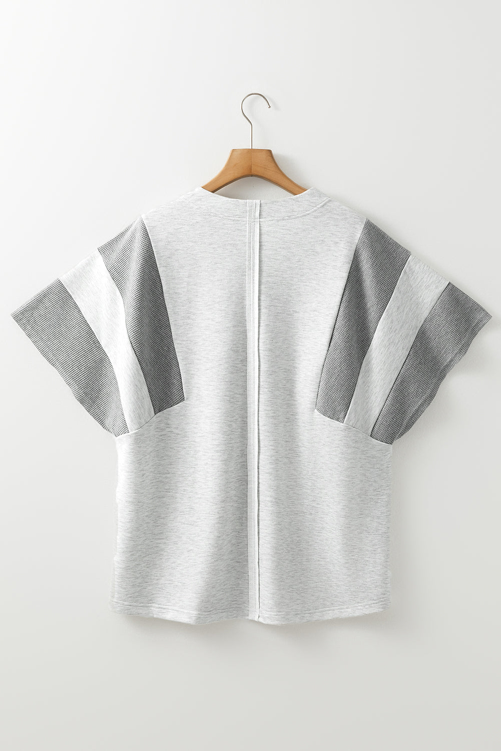Colorblock waffle knit henley top in gray with striped sleeve details.