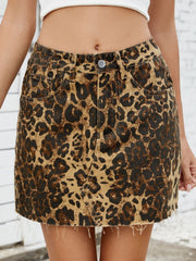 Leopard print denim skirt with raw hem and five-pocket styling.
