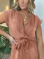 Orange tie-waist romper with button-down front and cuffed sleeves.