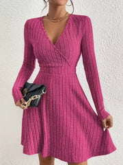 Fuchsia pink ribbed wrap mini dress with long sleeves and V-neck.