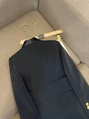 Black double-breasted tailored blazer with satin lapels and gold buttons.
