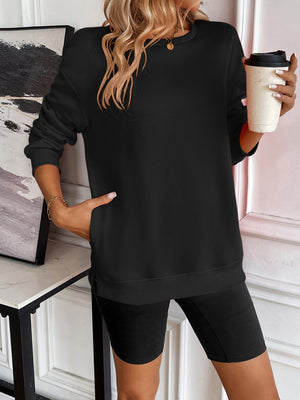 Black relaxed fit sweatshirt with crewneck, long sleeves, and side pockets.