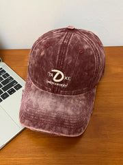 Embroidered vintage denim baseball cap in wine red with distressed details and white text embroidery.