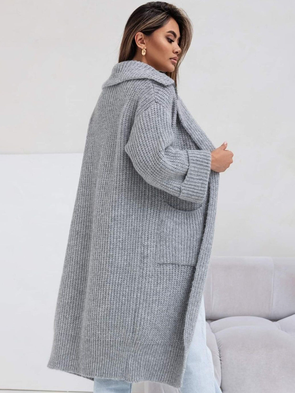 Gray oversized knit cardigan with lapel, pockets, and ribbed cuffs.