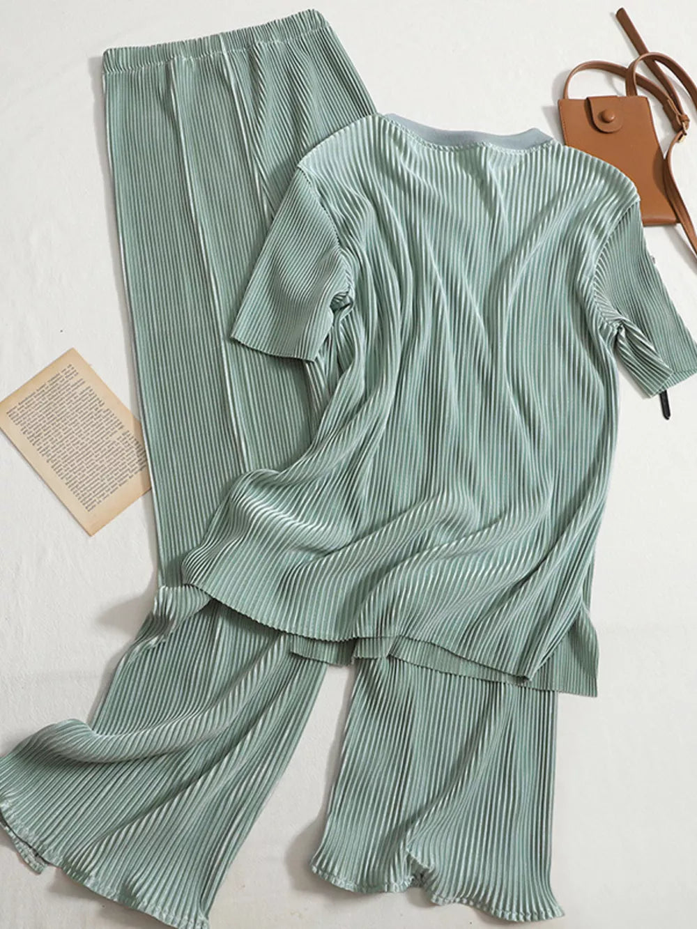 Elegant pleated two-piece set in olive green with short sleeves and wide-leg pants.