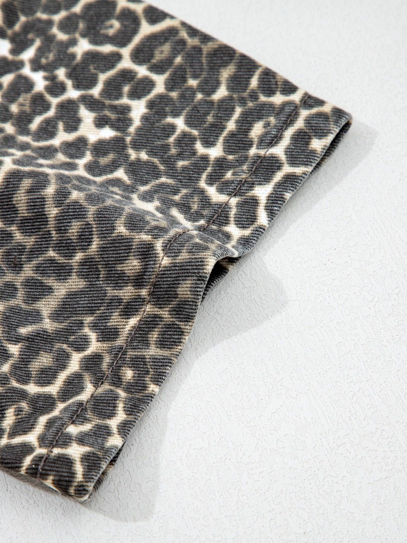 Denim shirt with leopard print, short sleeves, and a classic collar.