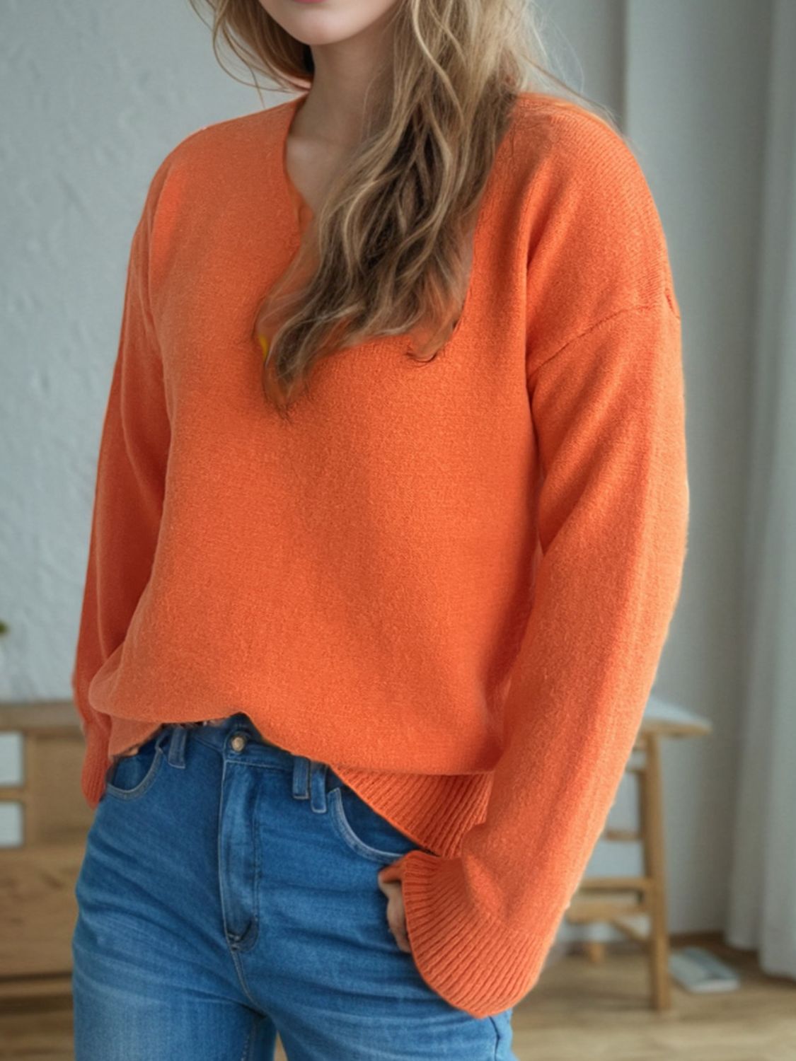 Orange V-neck knit sweater with ribbed hem and cuffs, relaxed fit, acrylic material.