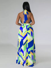 Halter neck maxi dress with geometric print and pleated skirt in blue, green, and yellow.