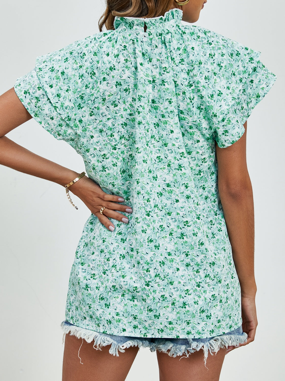 Light green floral blouse with ruffled neckline and flutter sleeves