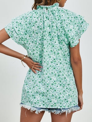 Light green floral blouse with ruffled neckline and flutter sleeves