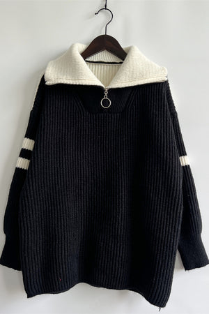 Black ribbed knit quarter-zip sweater with white collar and striped sleeves.