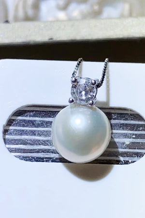 Solitaire pearl pendant necklace in silver with a clear cubic zirconia accent.