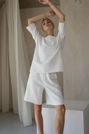 White relaxed fit sweatshirt and shorts set with seam details and raw edges.