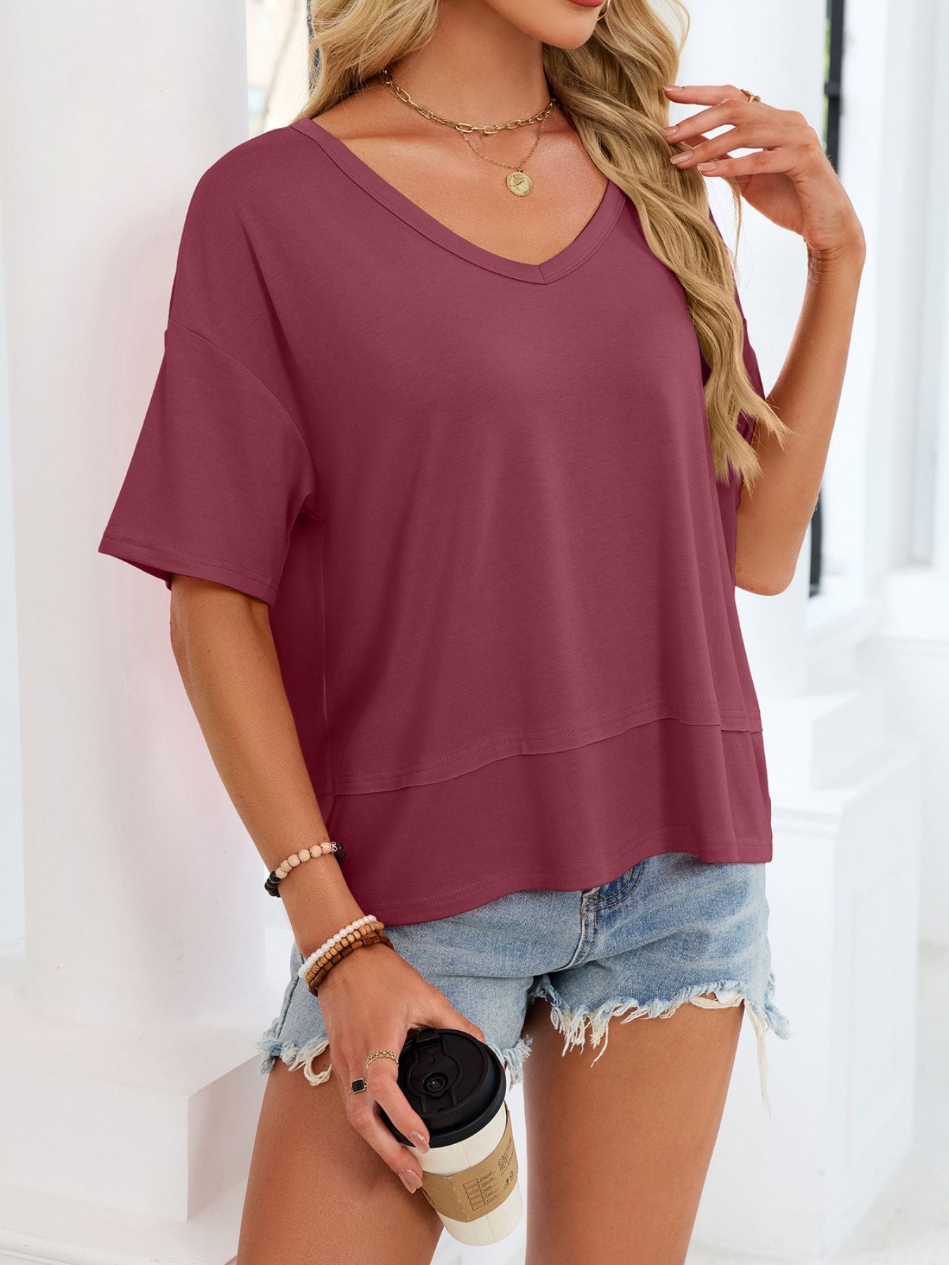Relaxed fit V-neck t-shirt in wine red with short sleeves and a layered hem detail.