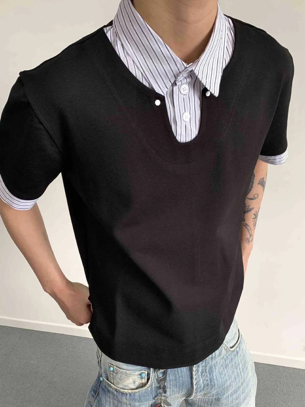 Black layered polo shirt with striped collar and button placket detail