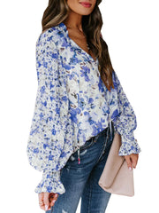 Blue floral print tie-detail blouse with long balloon sleeves and ruffled cuffs.