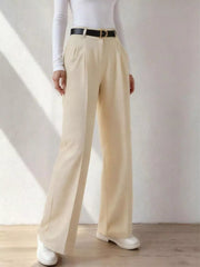 Beige wide-leg dress pants with pockets, belt loops, and a pleated front, styled with a black belt.