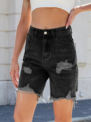 Black distressed denim Bermuda shorts with frayed hem and rips.