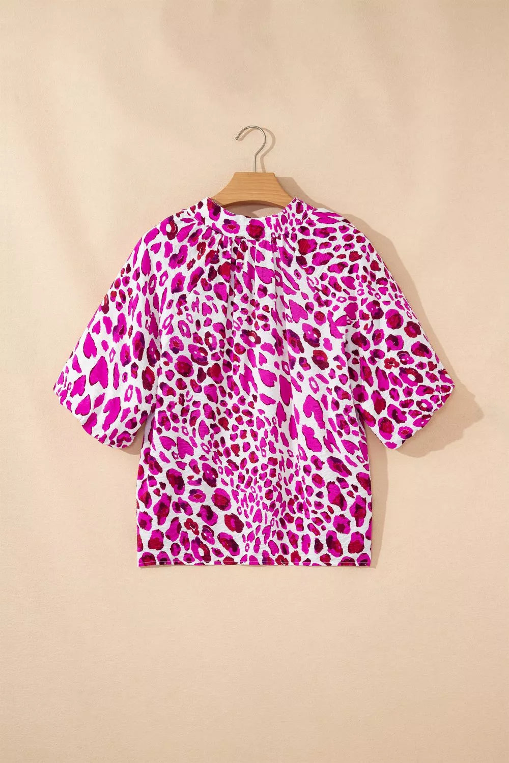 Vibrant leopard print blouse with short sleeves and a mock neck.