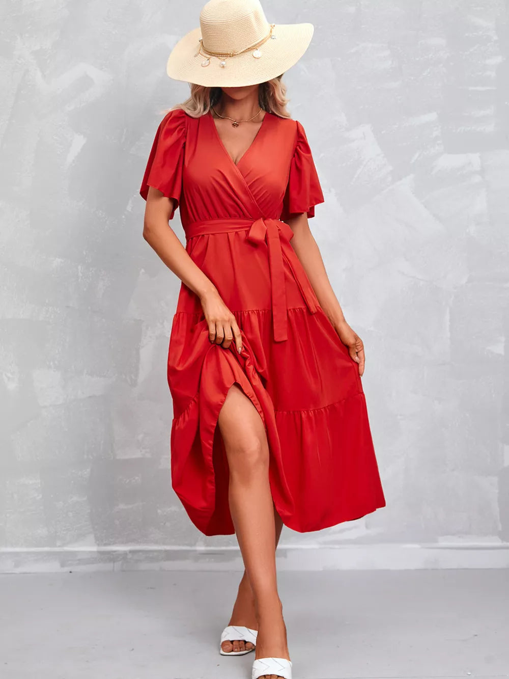 Orange-red flutter sleeve tiered midi dress with a belted waist and V-neck.