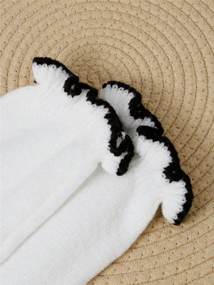 White knit sweater with black ruffled trim detail