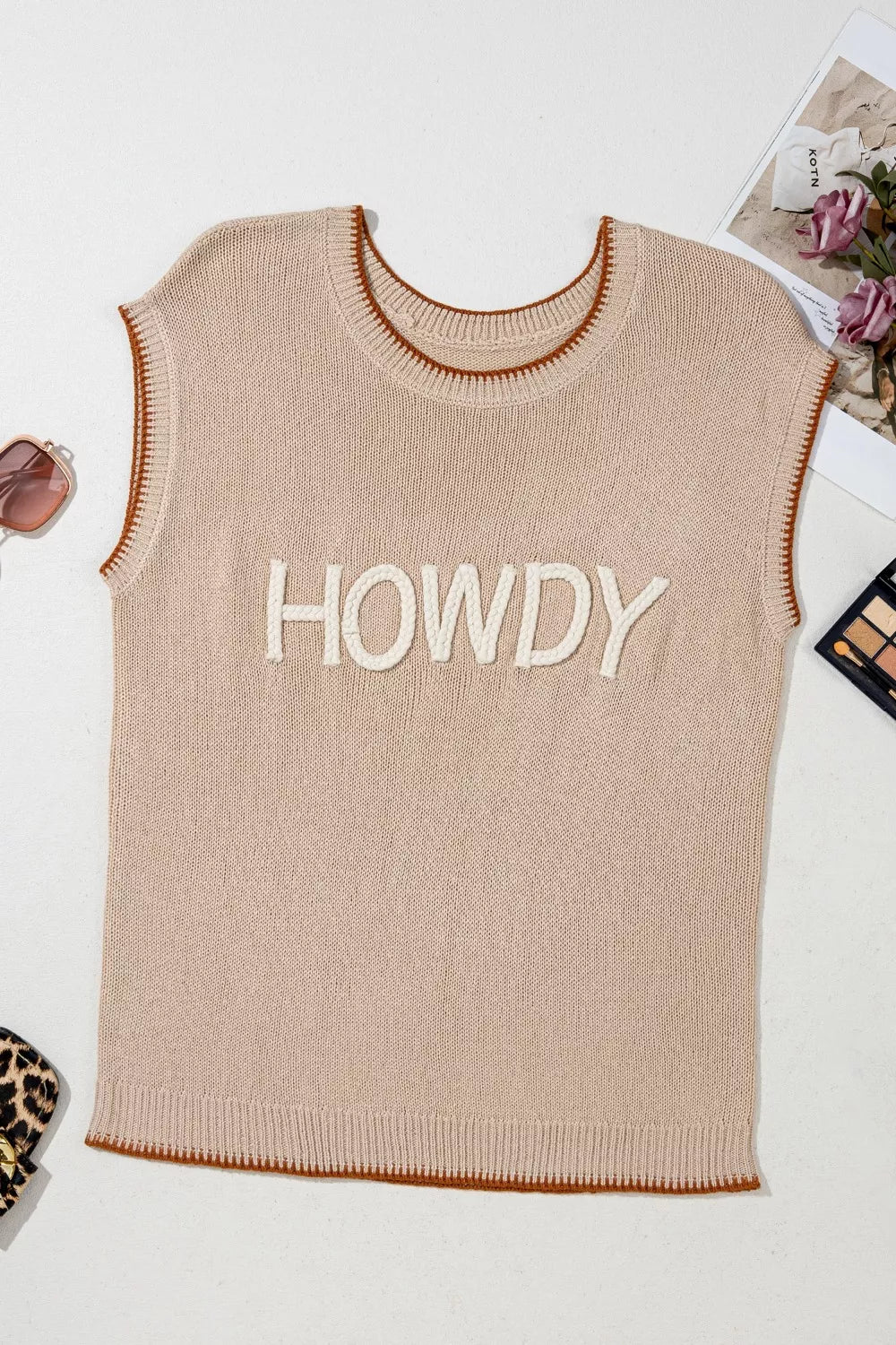 Howdy textured knit sweater vest in beige with brown trim and white rope lettering.