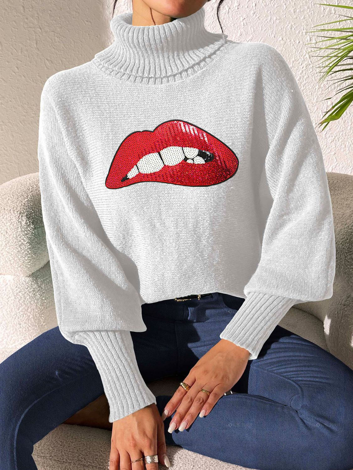 White turtleneck sweater with sequin red lips detail and balloon sleeves.
