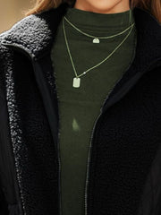 Black quilted sherpa panel zip jacket with a mock neck and layered necklaces.