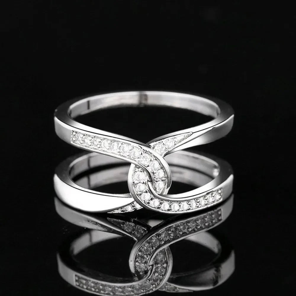 Silver pavé band ring with intertwined design.