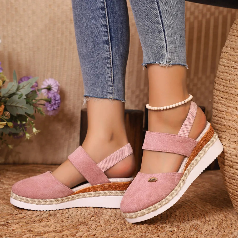 Dusty pink espadrille wedge slingback sandals with braided jute detail and elastic straps.
