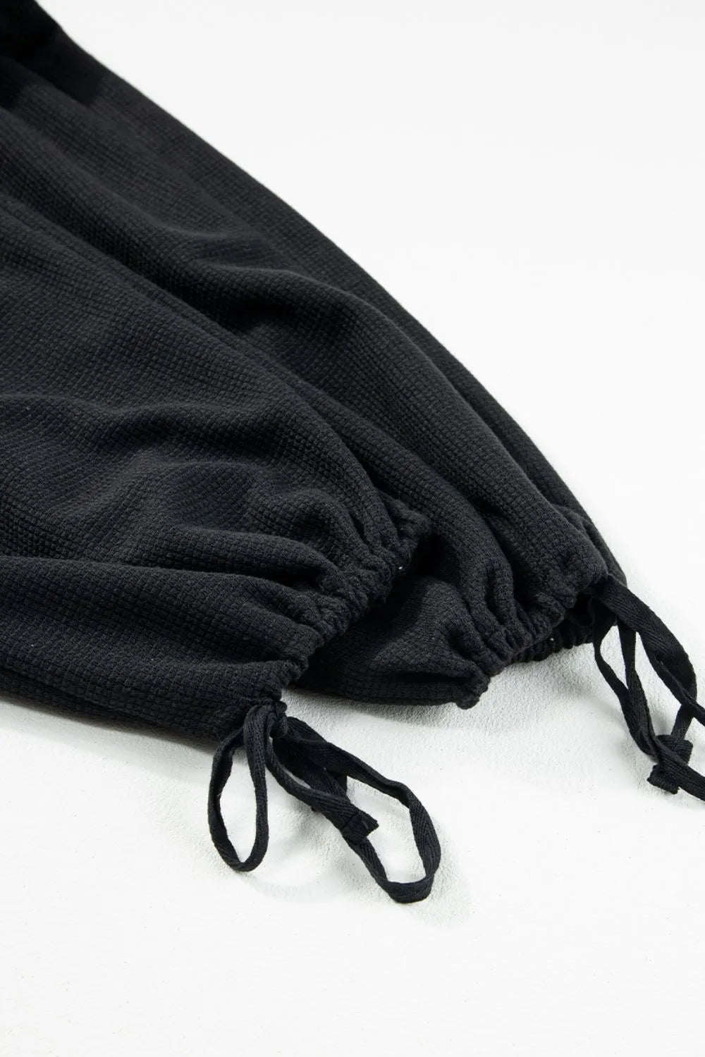 Black waffle knit jumpsuit with drawstring ankles