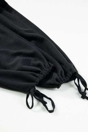 Black waffle knit jumpsuit with drawstring ankles