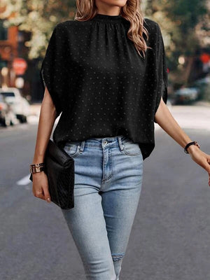 Black textured dot back-tie blouse with mock neck and short sleeves.
