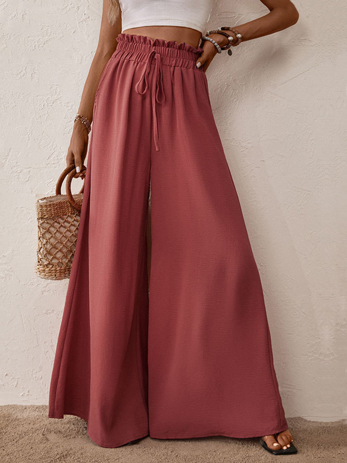 Ruffled waist palazzo trousers in rust with a drawstring and high leg slits.