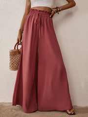 Ruffled waist palazzo trousers in rust with a drawstring and high leg slits.