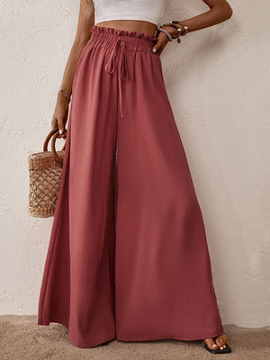 Ruffled waist palazzo trousers in rust with a drawstring and high leg slits.