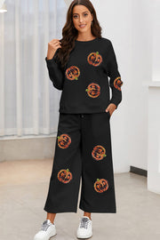 Black textured loungewear set with allover pumpkin print, crewneck top and wide-leg pants.