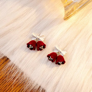 Velvet bell earrings in deep red with white bows and gold bead accents.
