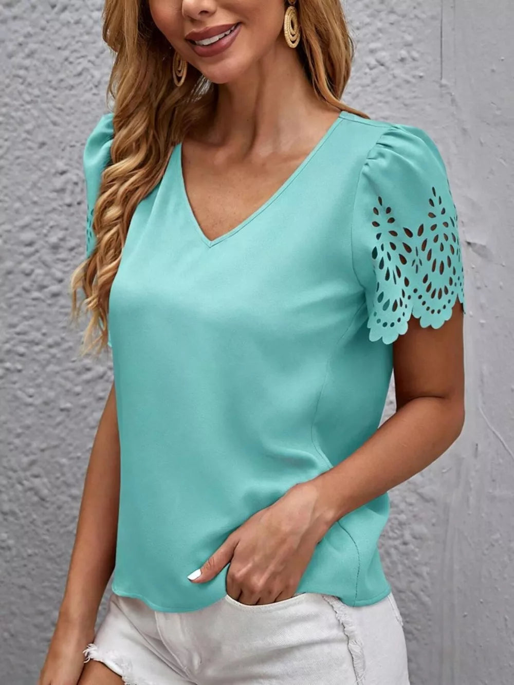 Teal V-neck blouse with cutout lace detail on short sleeves.