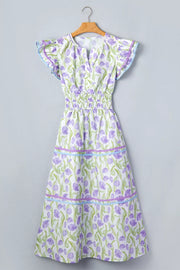 Lavender tulip print midi dress with smocked waist, flutter sleeves, and tiered skirt with ribbon trim.